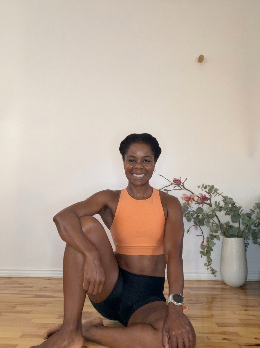 Dani smiling in workout gear on a wooden studio floor